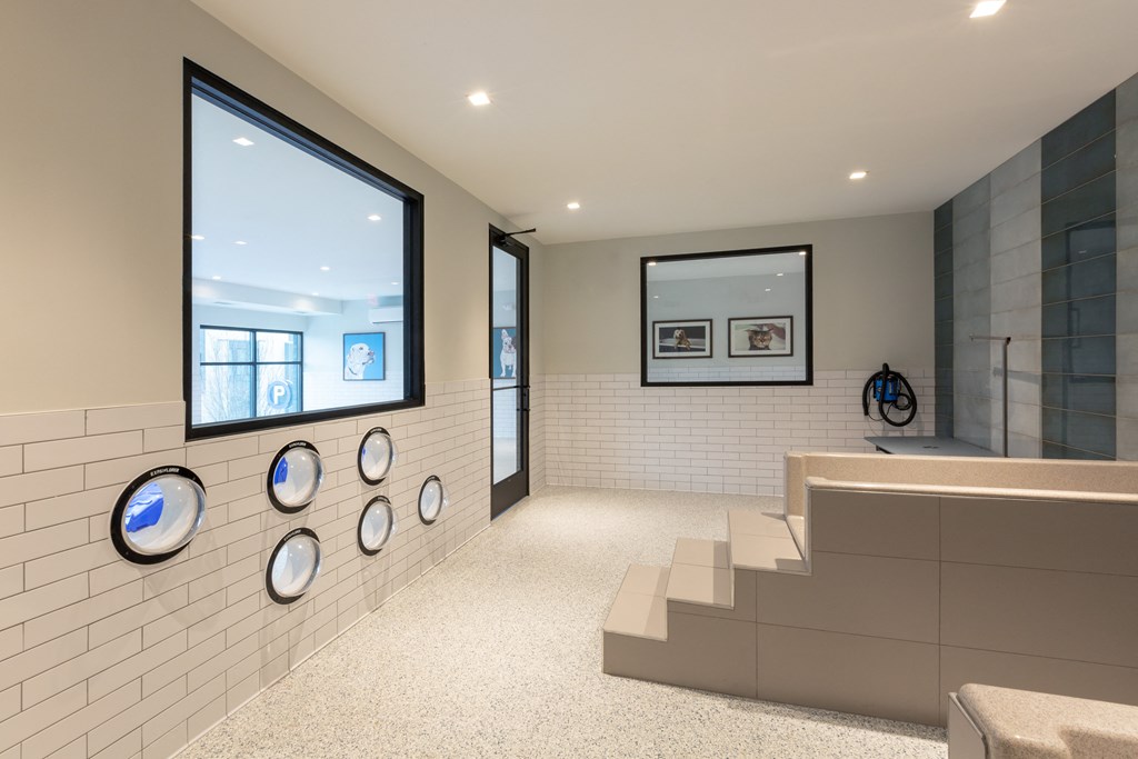 a view of a room with a staircase and a wall with clocks on it
