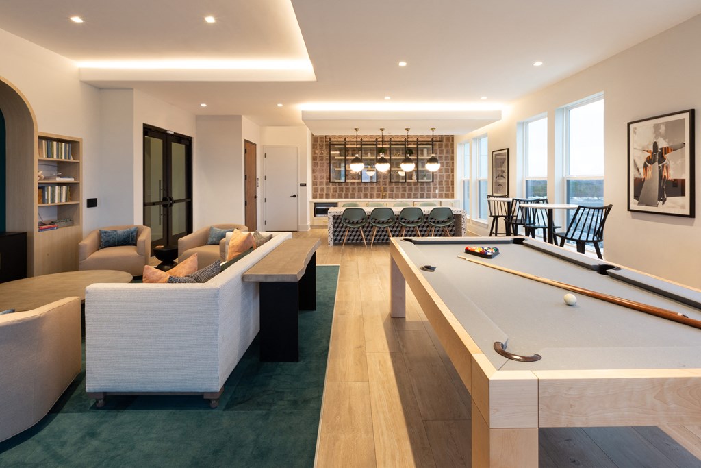 a living room with a pool table and a dining room