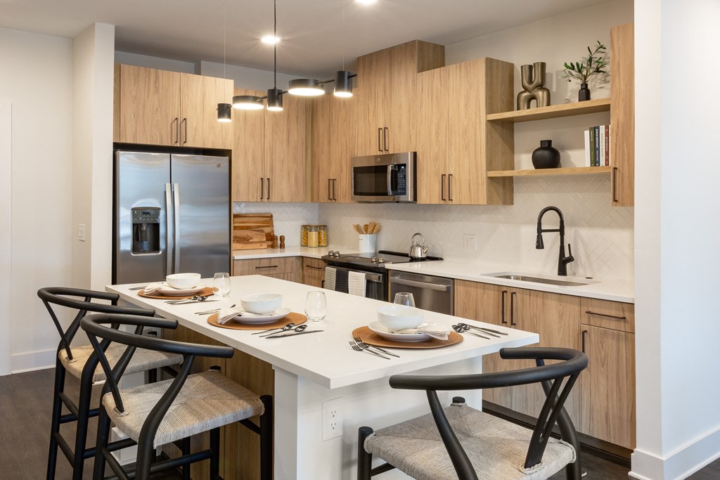 a kitchen with a large island with chairs and a table