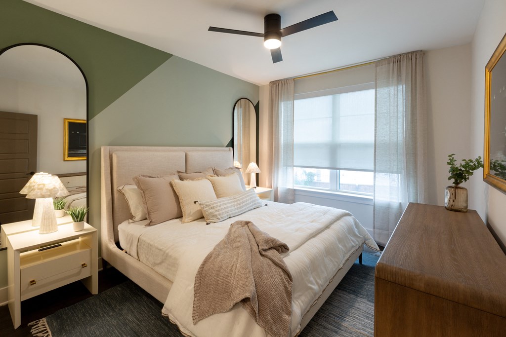 a bedroom with a white bed and a large mirror