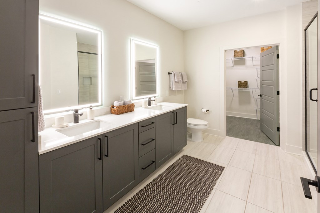 a bathroom with two sinks and a shower and a toilet