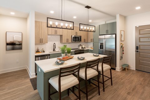 a kitchen with a large island with chairs