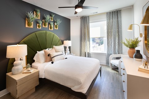 a bedroom with a large bed and a green accent wall