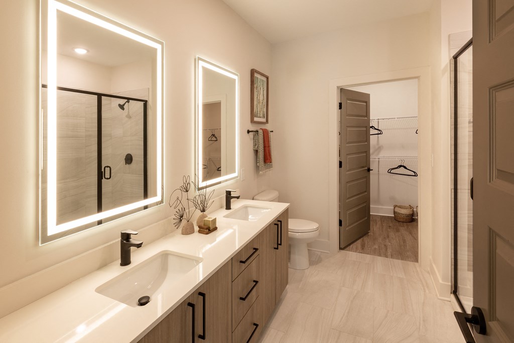 a bathroom with two sinks and a shower and a toilet