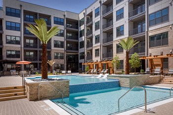 Multi-level swimming pool with infinity edge and sun ledges. - Photo Gallery 3