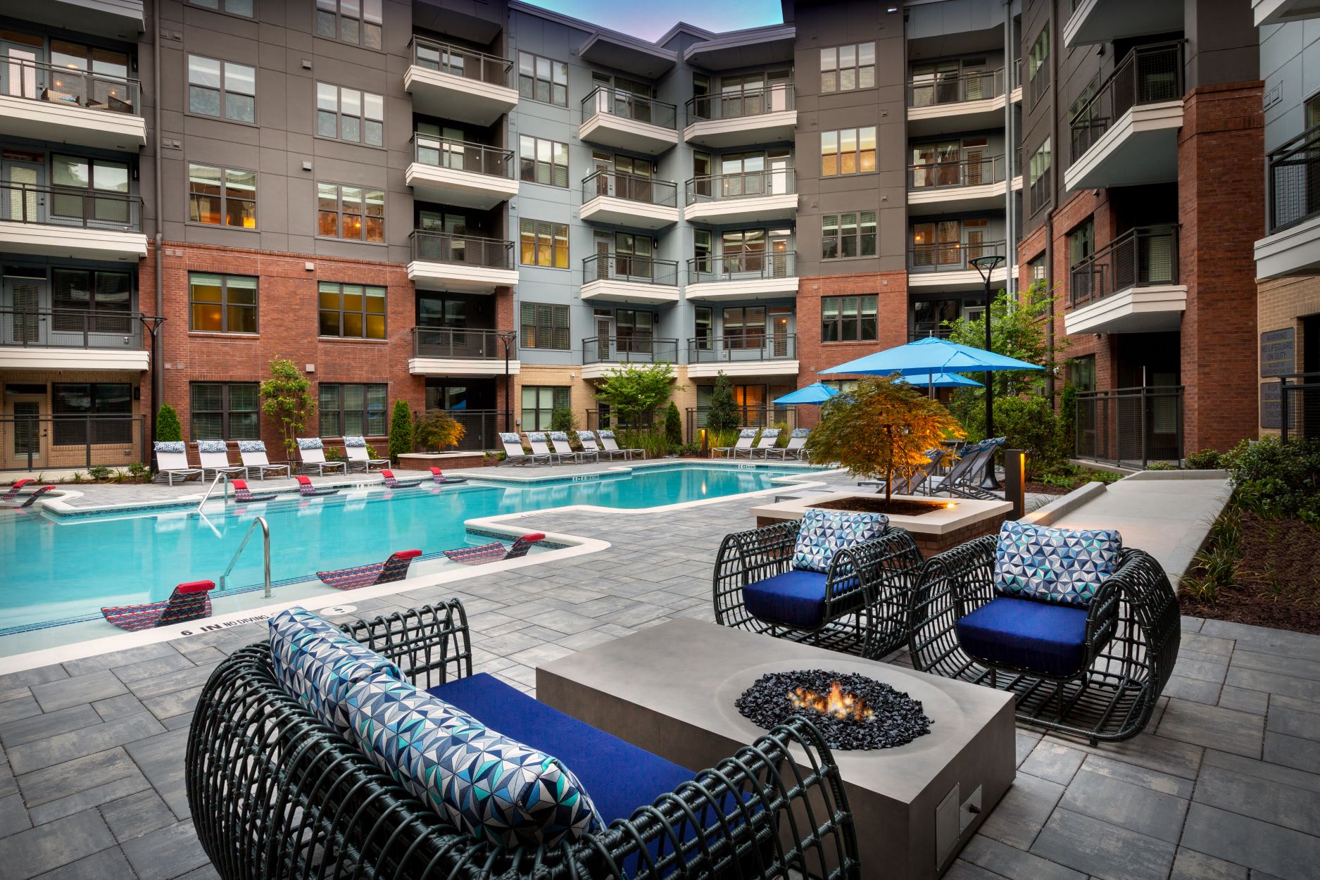 Sparkling pool with lounge chairs and fire pit.