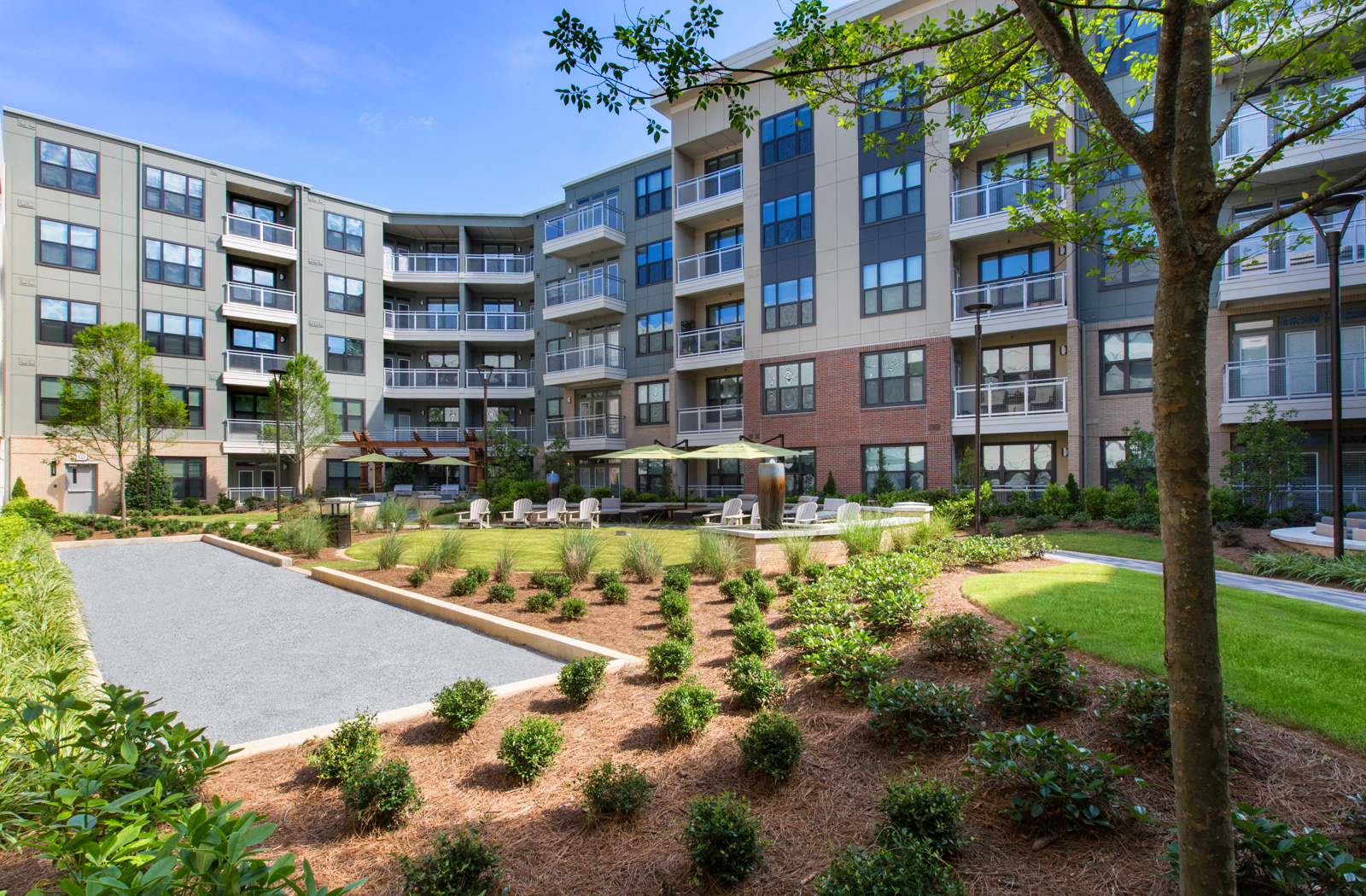 Courtyard area with manicured lawns, lawn chairs, and shaded seating areas. 