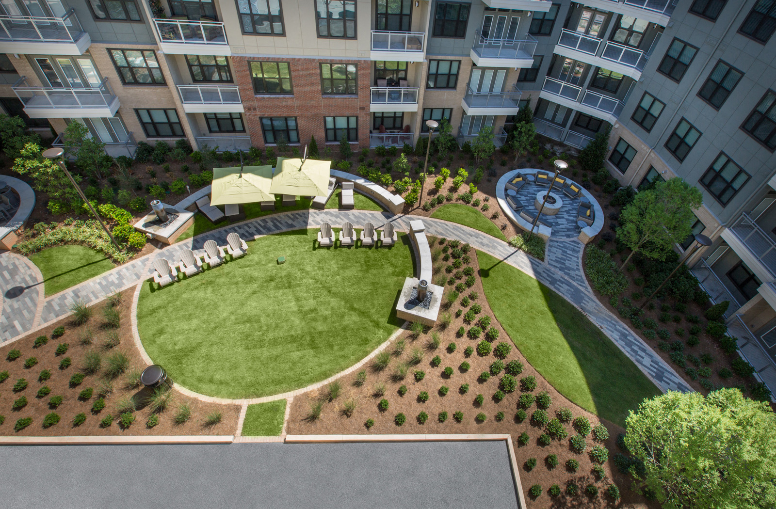 Aerial view of the courtyard area with manicured lawns, lawn chairs, and shaded seating areas.