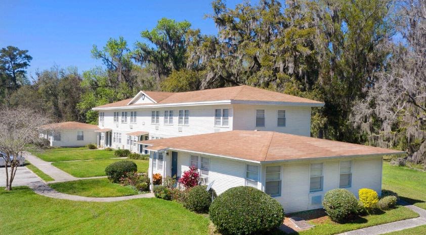 a white house with a yard and trees