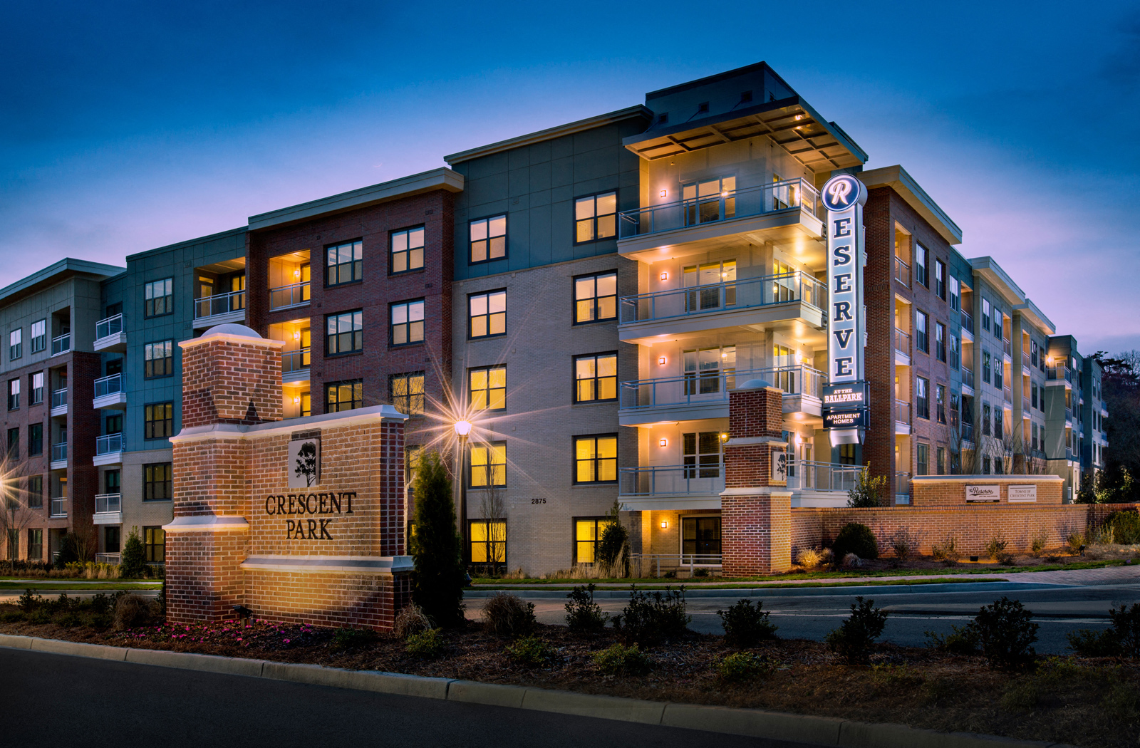 Exterior view of The Reserve apartment building during nighttime. 