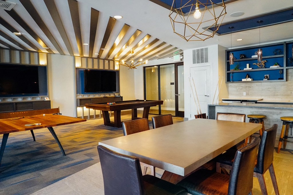 Resident gaming room with table tennis, pool table, and 2 mounted TVs.