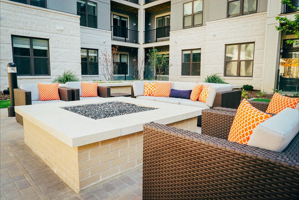 Outdoor firepit area with multiple comfortable seating options surrounding it.