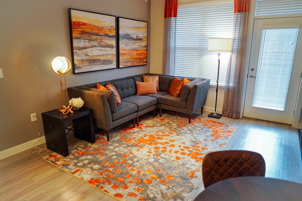 Corner couch in the furnished living room space on wooden floors. 