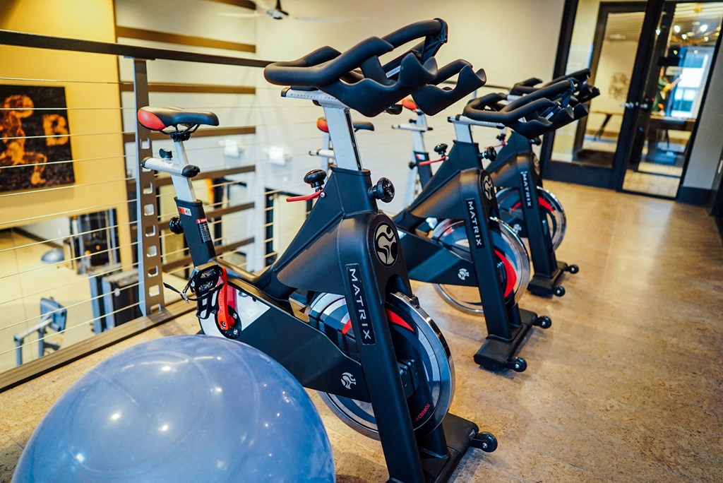 Workout bikes and a yoga ball on the second floor of the fitness center.