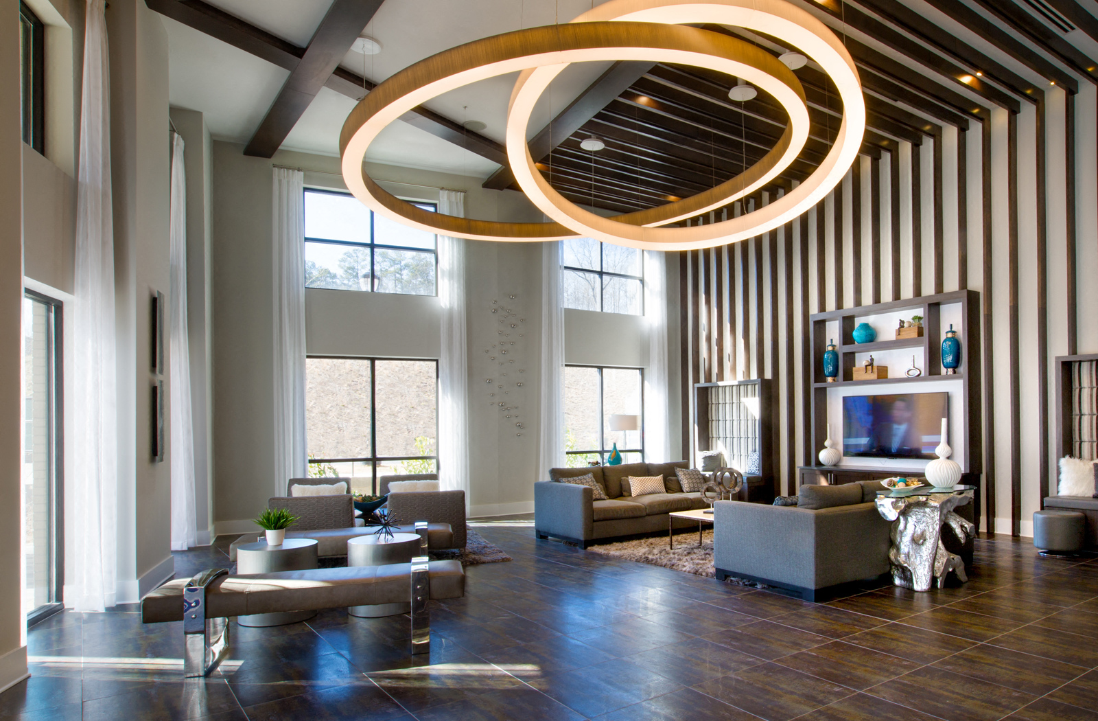 Lobby area with multiple seating options, a mounted TV, and large windows. 
