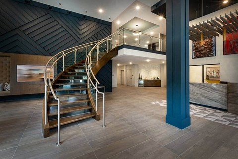 Fully furnished lobby with a curved staircase.