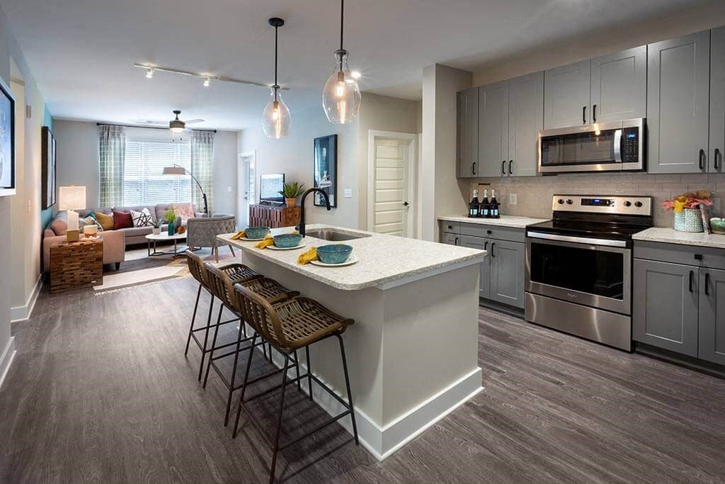 Kitchen with stainless steel appliances and a breakfast bar and 3 stools.