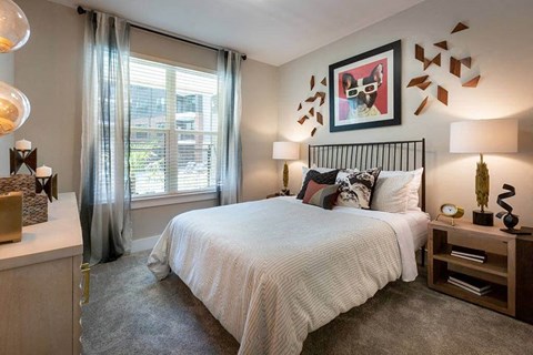 Bedroom with a queen sized bed and large window.