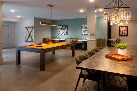A modern dining room with a long table and chairs.