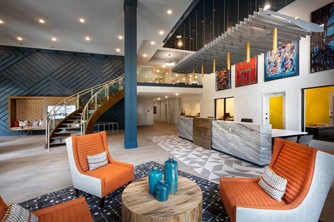 A living room with orange chairs and a wooden coffee table.