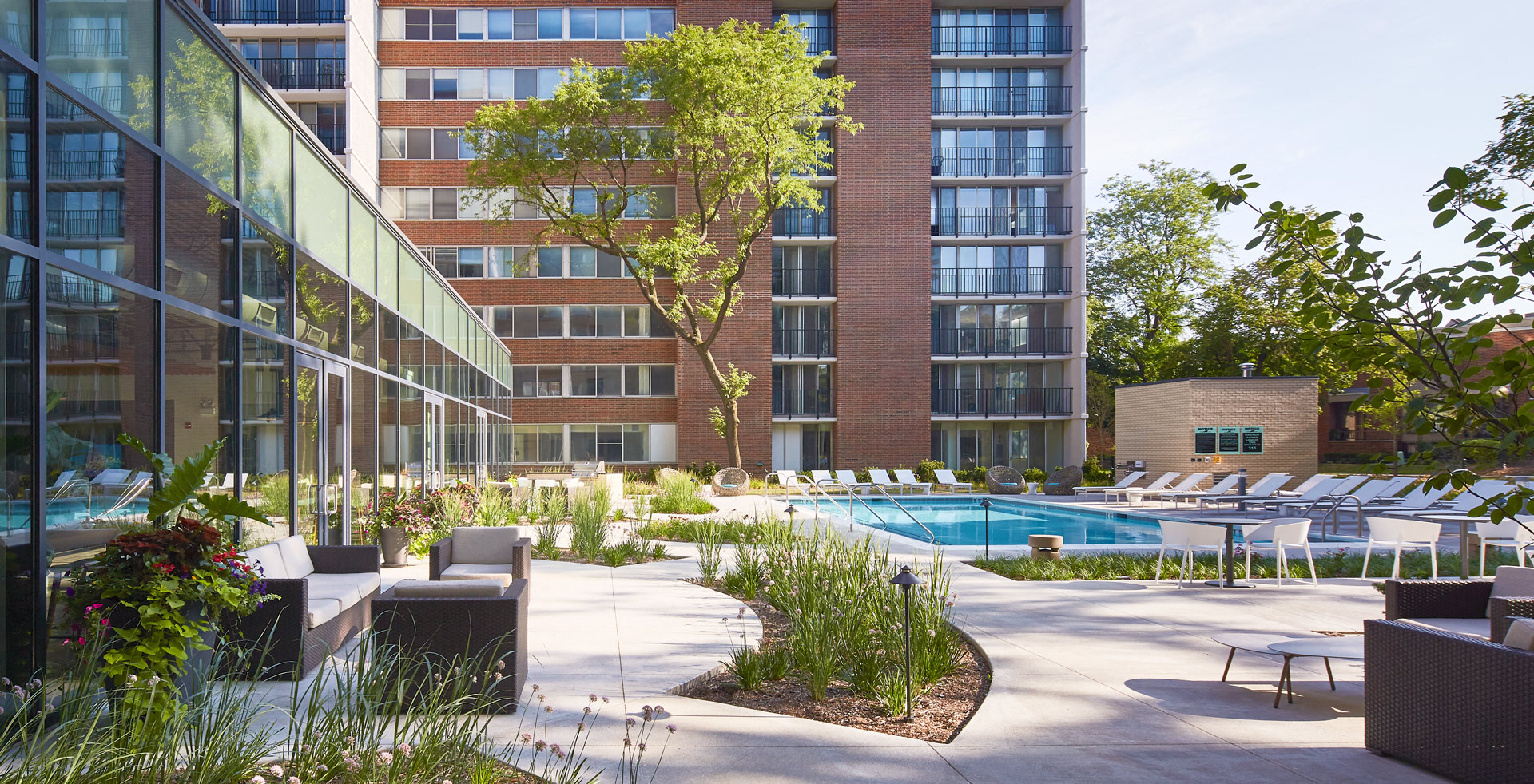 Outdoor pool area with lots of seating options on a sunny day.