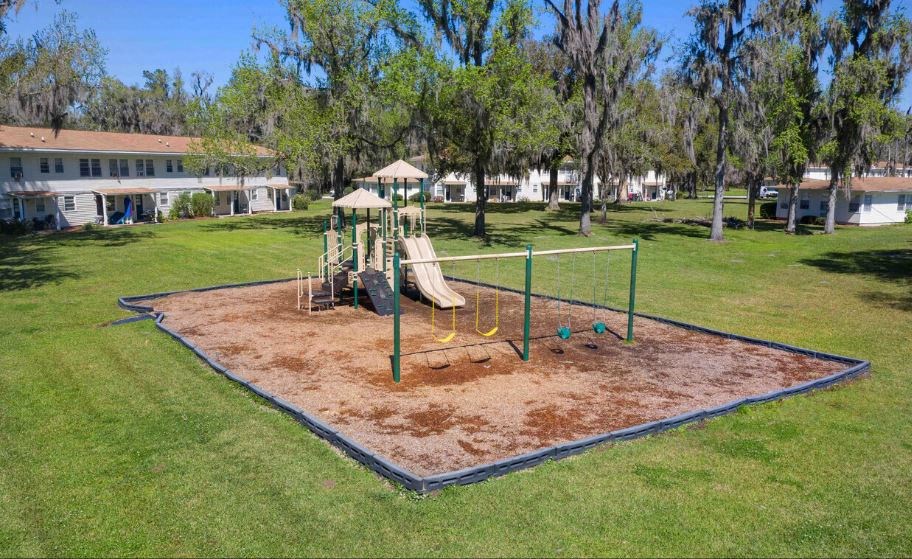 a playground with a swing set in a park
