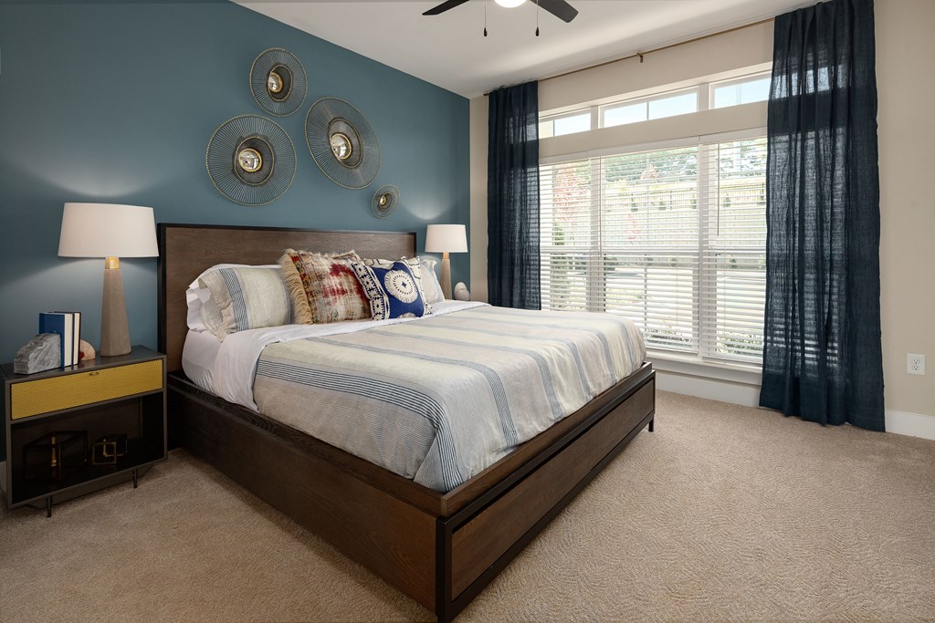 A bedroom with a large bed and a ceiling fan.
