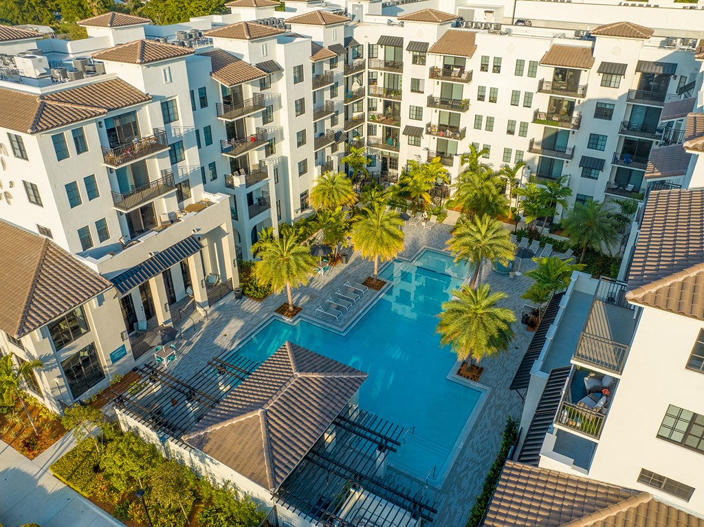 an overhead view of an apartment building with a large swimming pool