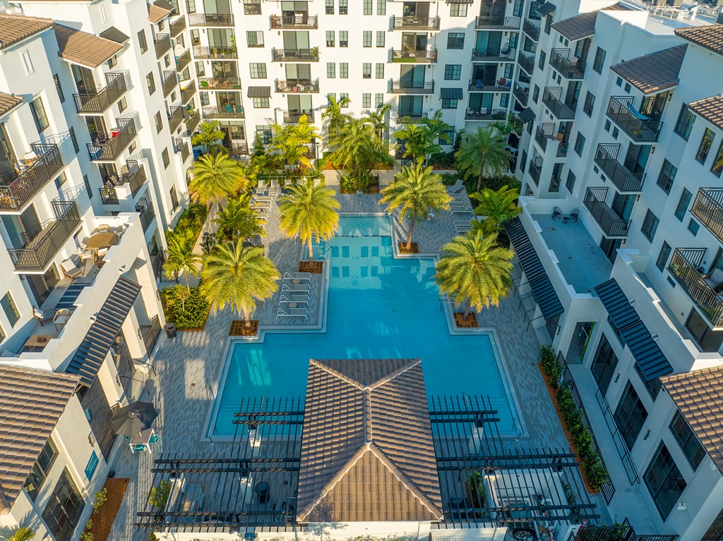 a view of the pool at an apartment building with palm trees