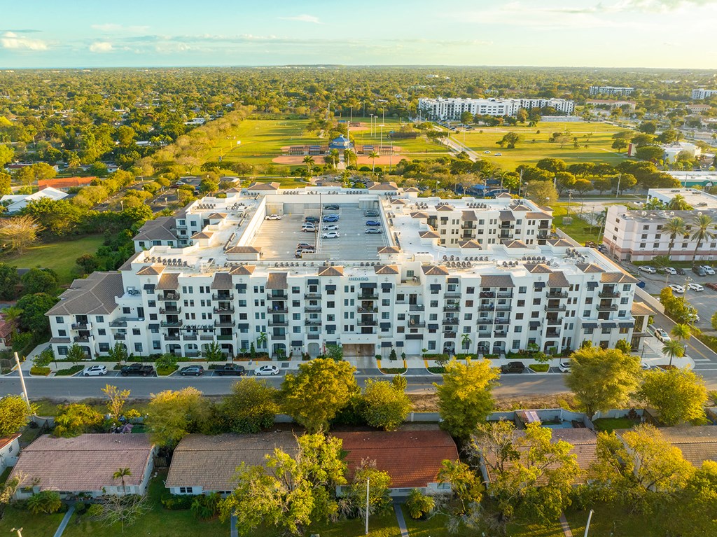 an aerial view of an apartment complex with trees and a parking lot