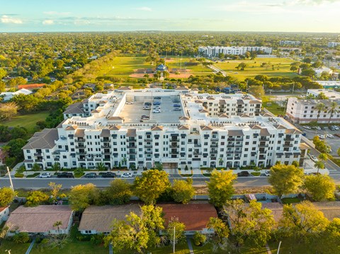 an aerial view of an apartment complex with trees and a parking lot