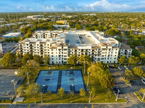 an aerial view of a tennis court in front of a large building