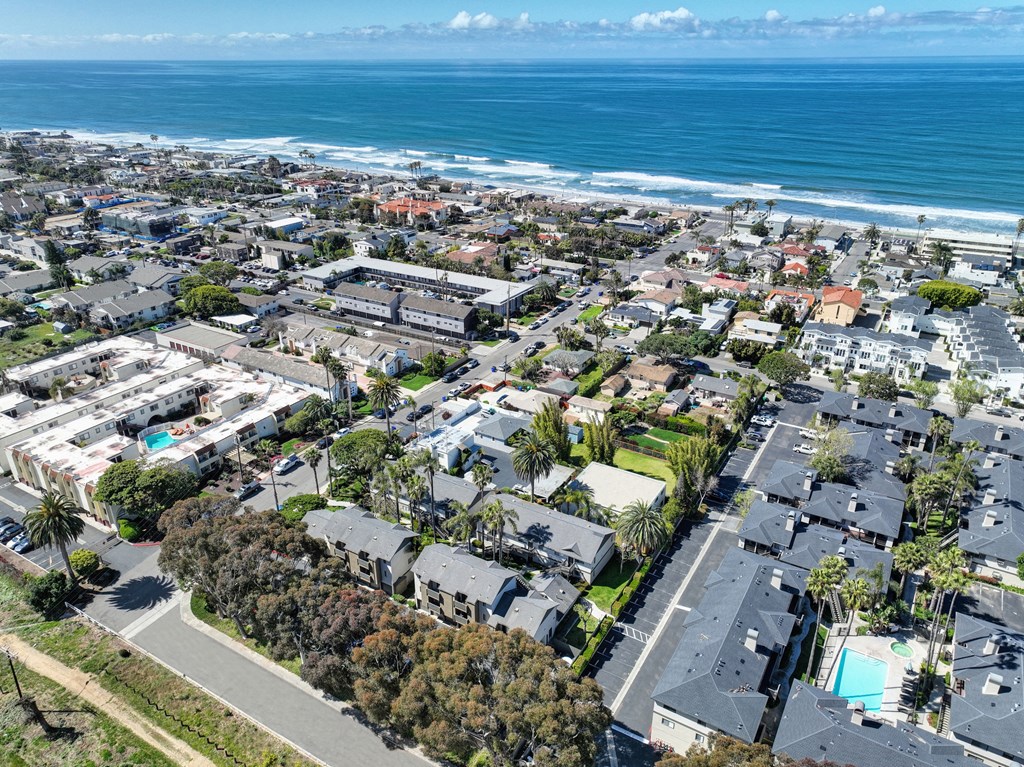 an aerial view of a city with the ocean in the background