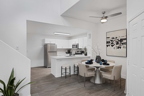 A modern kitchen with a dining table set for two.