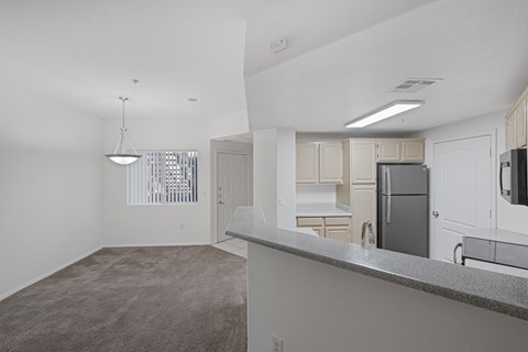A kitchen with white cabinets and a grey counter.