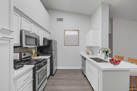 A kitchen with white cabinets and a black stove top oven.