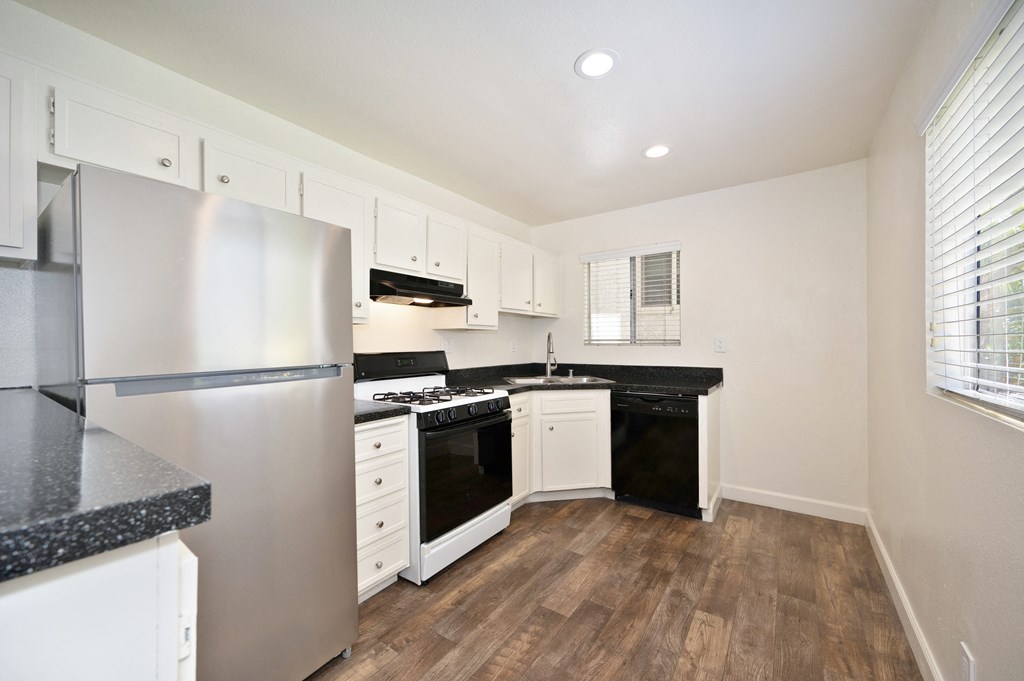 a kitchen with white cabinets and a stainless steel refrigerator