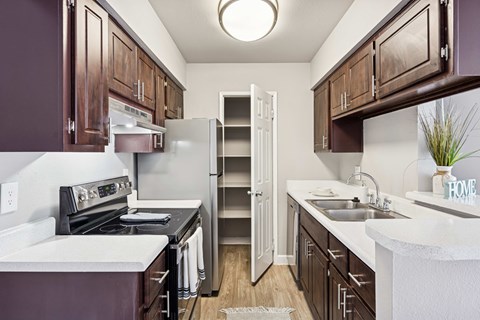 A kitchen with brown cabinets and a white counter.