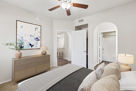 A bedroom with a large bed and a painting on the wall.
