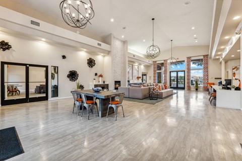 A modern living room with a dining table and chairs.
