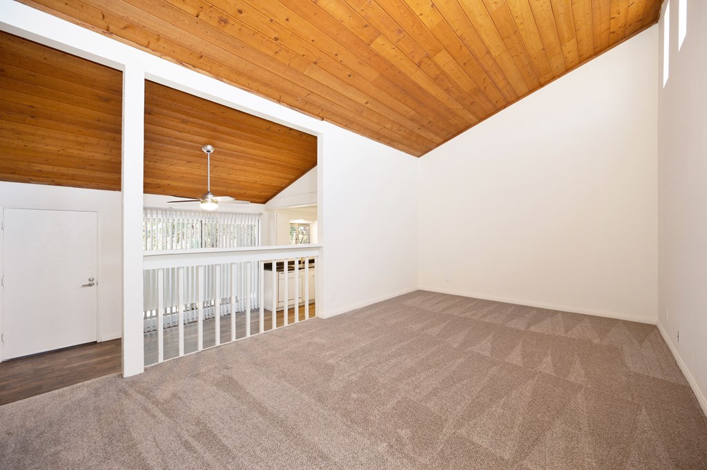 a living room with a carpeted floor and a balcony