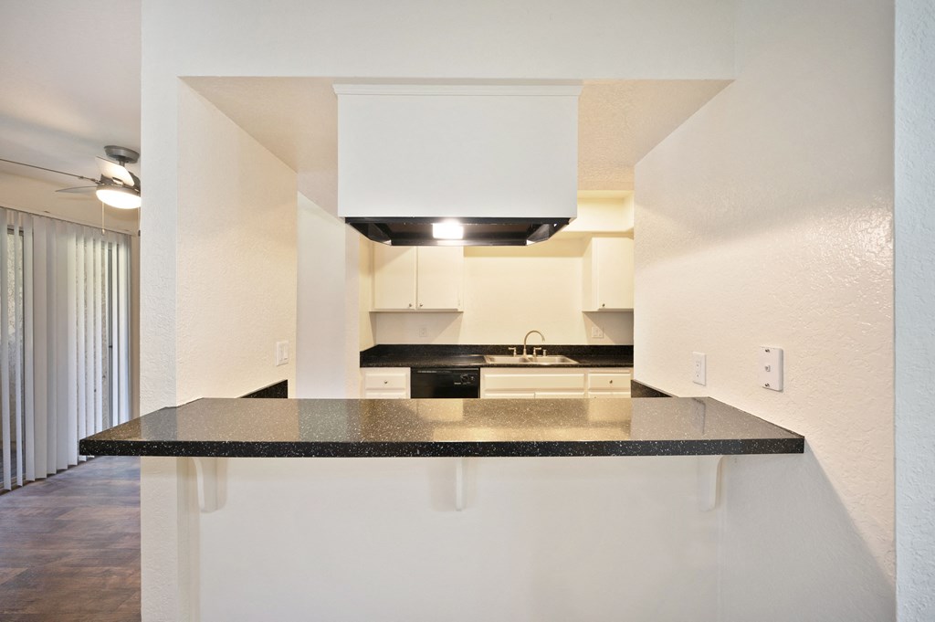 an empty kitchen with a counter top and a sink