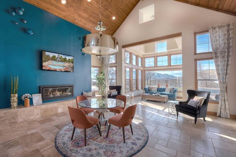 A living room with a fireplace and a painting of a pool.
