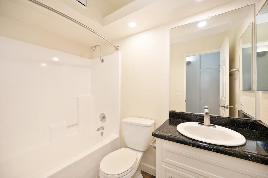 a bathroom with a toilet sink and shower and a mirror