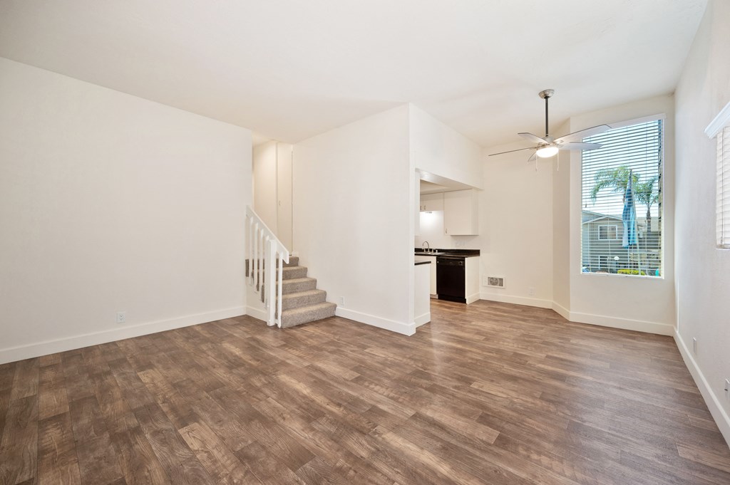 the living room and dining room of an empty home with wood flooring