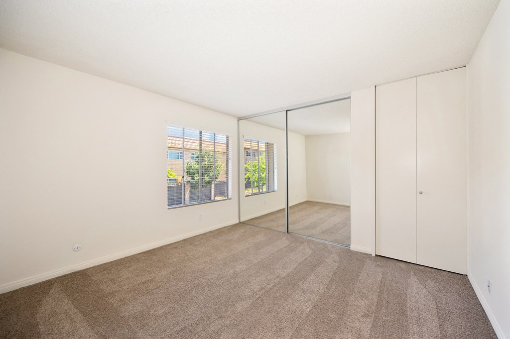 a living room with white walls and flooring and a large window