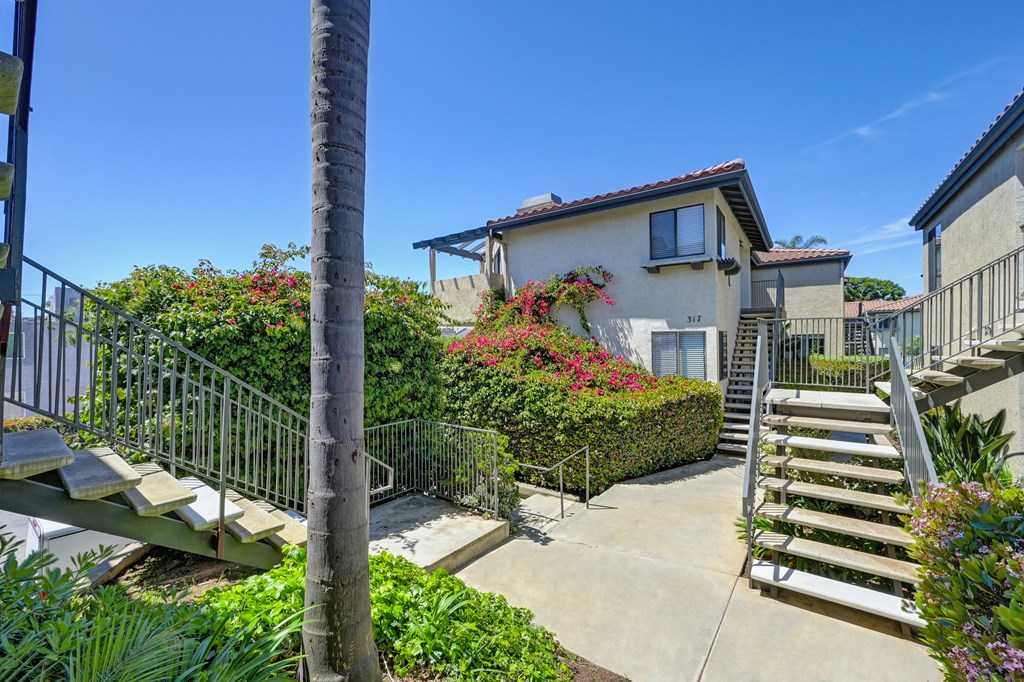 a house with stairs and a sidewalk in front of it