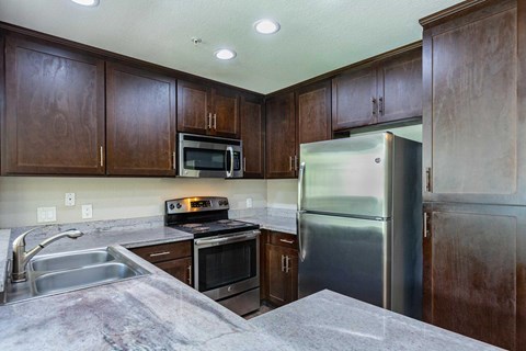 A kitchen with brown cabinets and stainless steel appliances.