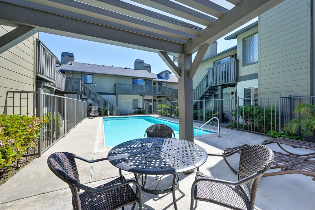 our apartments have a large pool and a patio with chairs