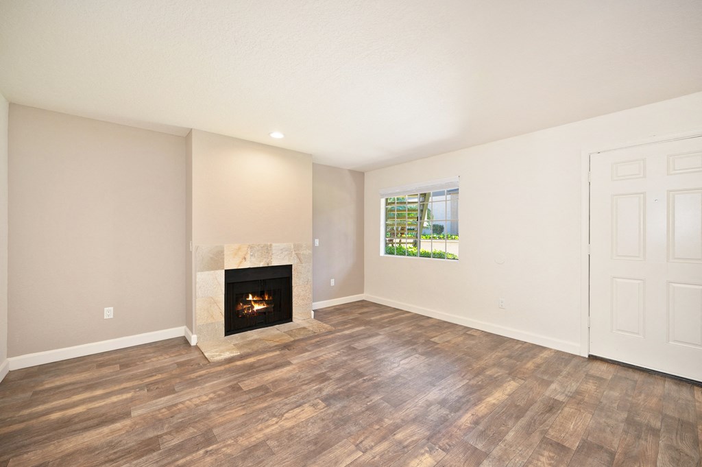 an empty living room with a fireplace and a window